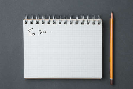 school notebook on a dark gray background, spiral notepad on a desk, to do list