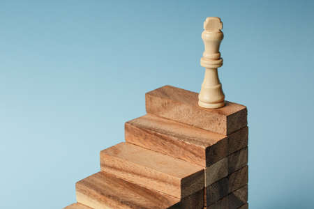 Chess standing on a pyramid of wooden building blocks. career ladder concept, Business hierarchy...