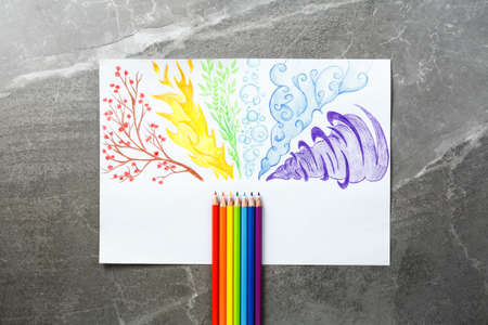 Colored pencils drawing rainbow smoke. Flat lay, pencils with color patterns of different elements...