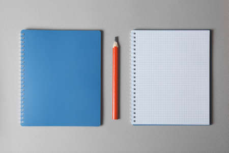 top view of a open blue notebook with red pencil on a gray background, school notebooks with a...