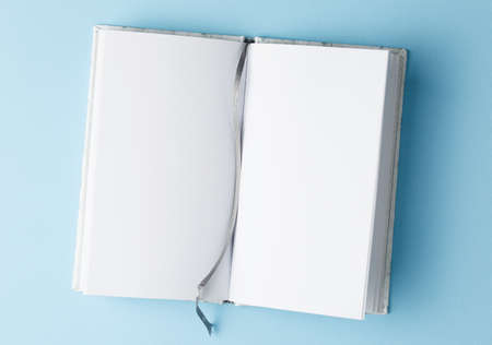 open school notebook on blue table top view, notepad with blank page. flat lay of office concept