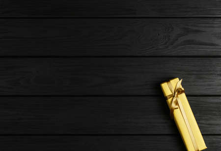 top view of a gift box on a black wooden background, gifts on a black table a flat lay, a festive...