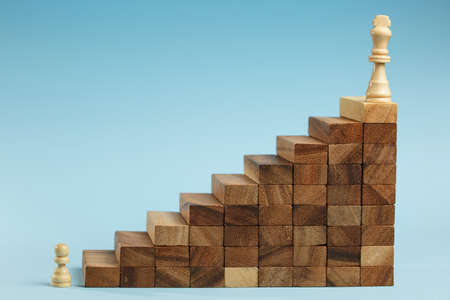 Chess standing on a pyramid of wooden building blocks. career ladder concept, Business hierarchy with copy space.の写真素材