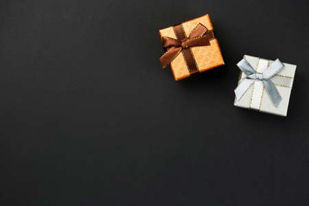 Gift boxes on a black background, holiday packages for wedding rings, top viewの写真素材