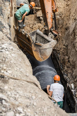 replacement of a sewer pipe deep under the ground, laying pipes under the ground, construction of a water supply line, repair of sanitary ware in Ukraineの写真素材