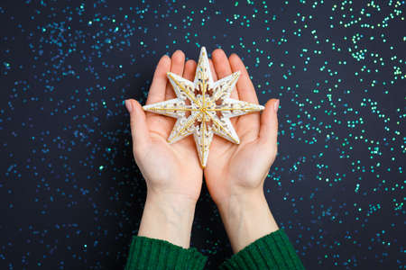 Christmas decorations on the hands, flat lay on a starry background, holiday greetingsの写真素材