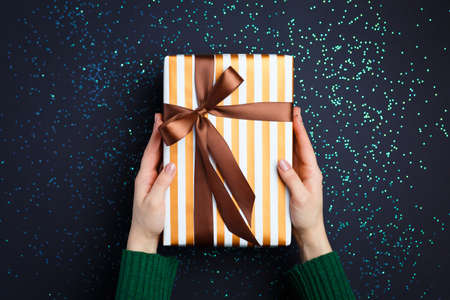 gift on the hands, flat lay on a starry background, holiday greetings
