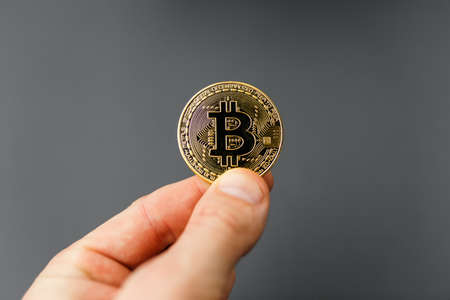 bitcoin in hand, coin bitcoin on the table, a lot of free space