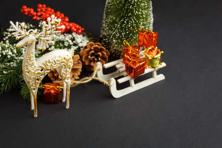 Christmas and New Year background with gifts, deer, stars and fir-trees, flat lay on a dark blue background, holiday greetings, concept of a winter background with free spaceの写真素材