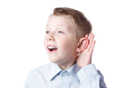 little boy holds a hand near the ear, a schoolboy portrait on an isolated white background