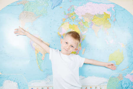 little boy on the background of the world map in Ukrainian, a schoolboy in the lesson of geographyの写真素材