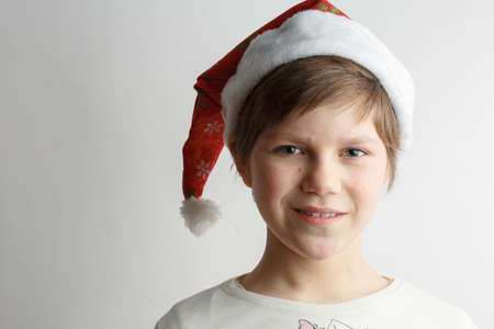 cheerful child posing in Santa's red hat, festive mood, christmas and birthdayの写真素材