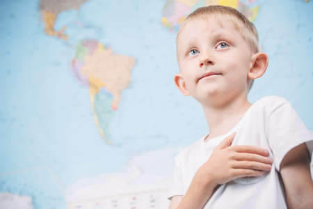 little boy on the background of a world map, a schoolboy at a geography lessonの写真素材