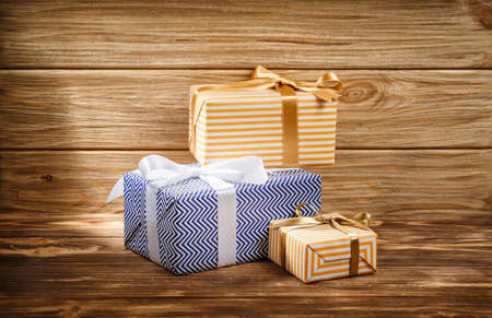 Many gifts box with ribbon on wooden background top view. New year and Christmas holiday concept. Flat lay with copy space. Discount gift for sale day.の写真素材