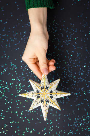 Christmas decorations on the hands, flat lay on a starry background, holiday greetings