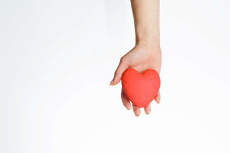 female hand with red heart on palm, isolated on white background. concept of a healthy lifestyle and loveの写真素材
