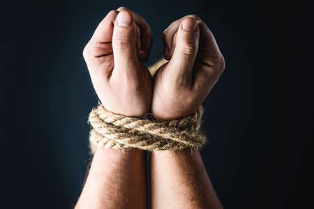 hands tied with a rope on a black background, the concept of stealing people, right dayの写真素材
