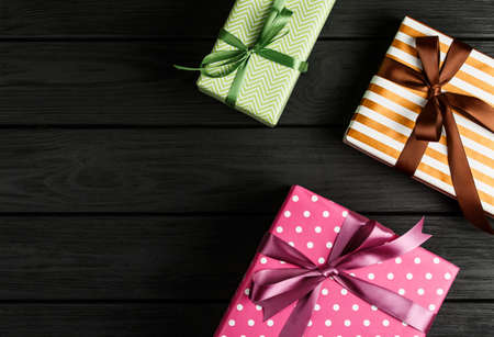 top view of a gift box on a black wooden background, gifts on a black table a flat lay, a festive...