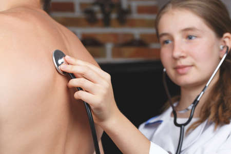 doctor listening to the patient's breathing through the stethoscope, the nurse listens to the...