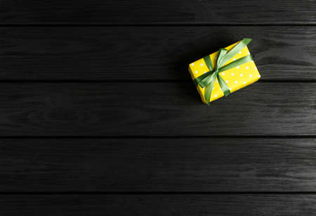 top view of a gift box on a black wooden background, gifts on a black table a flat lay, a festive...