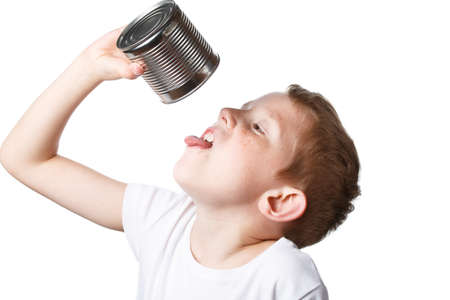 child eats from a tin can, starving boy looking to eat, photo isolated on a white backgroundの写真素材