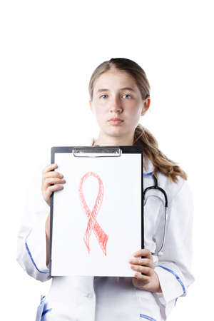 woman doctor holding a tablet with a red ribbon symbol combating cancer and AIDS, isolated on a white background. Day against HIV and Cancerの写真素材