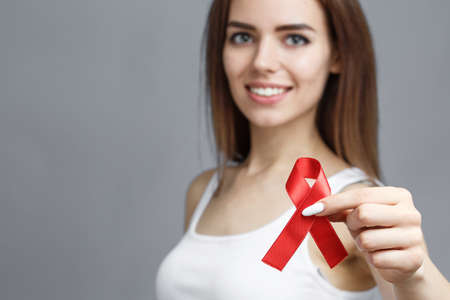 female hands holding red AIDS awareness ribbon, healthcare and medicine conceptの写真素材