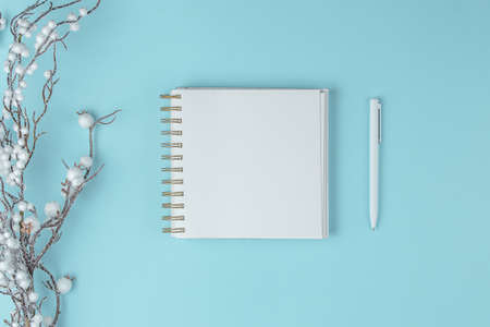 notepad on blue background with Decorated white twigs, holiday concept flat lay. new goals, plans and to do list top view.の写真素材