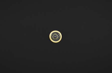 one condom on black background, flat layer, the concept of the fight against HIV and aids