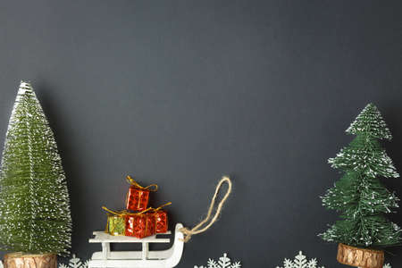 Christmas and New Year background with gifts, deer, stars and fir-trees, flat lay on a dark blue background, holiday greetings, concept of a winter background with free spaceの写真素材