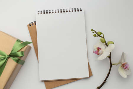 Notebook on white table with gift box and pencil