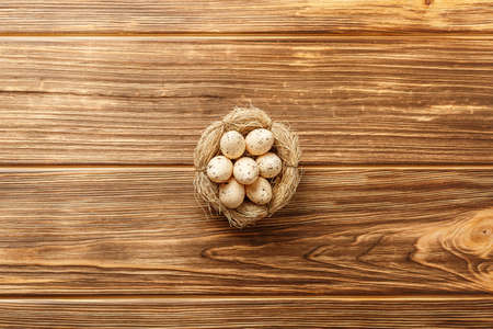 easter composition top view. eggs in the nest on rustic wooden background flat lay with space for...
