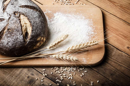 bread on the table, homemade bread with flour and grain on a wooden backgroundの写真素材