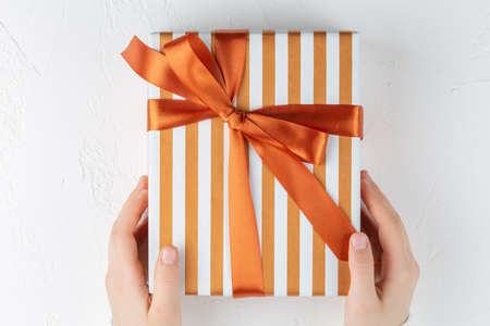 Girls hands hold gift box. Goals plans dreams make to do list for new year concept of diary, holiday greetings or planning. Flat lay, top view, mockup.の写真素材