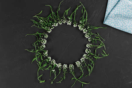 decorative background of flowers in a circle on a black background with a cloth top view, flat lay,...