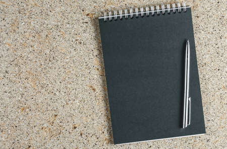 open black notebook with pen on table top view, spiral notepad with blank page. flat lay of office...