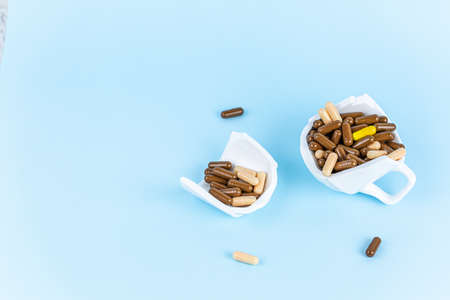 pills in a broken white cup. Insurance medicine concept. Medical preparations on the table.