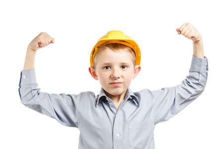boy in yellow construction helmet shows strength up on white isolated background, young engineer...