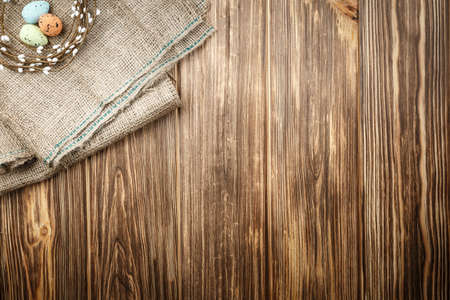 Easter background with painted eggs on wooden background top view, festive background with an open space for writing text flat lay.の写真素材