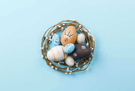 Easter background with painted eggs on a blue background top view, festive background with an open...