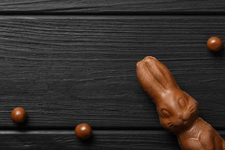 easter composition top view. chocolate bunnies with colorful candies on black background flat lay with space for textの写真素材