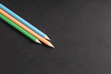 colored pencils in row on black background top view. Art set of pencils for schoolboy with free space. view from aboveの写真素材