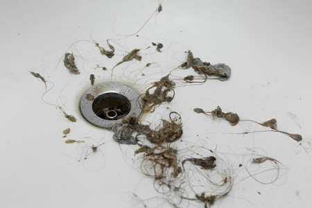 close-up dirt and hair near the drain hole in the bathroom, cleaning the sink plumberの写真素材