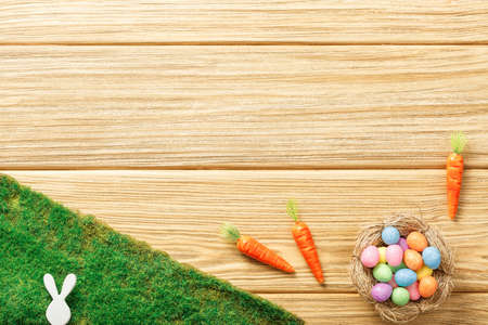 easter composition top view. eggs in the nest on wooden with grass background flat lay with space...