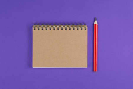 school notebook with pencil on the violet background, school notebook on the purple desk, office...