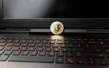 bitcoin on the keyboard, coin bitcoin on the table with the laptop, a lot of free spaceの写真素材