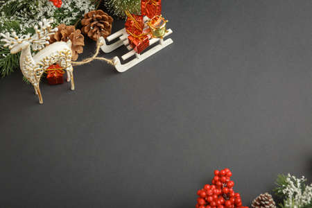 Christmas and New Year background with gifts, deer, stars and fir-trees, flat lay on a dark blue background, holiday greetings, concept of a winter background with free spaceの写真素材