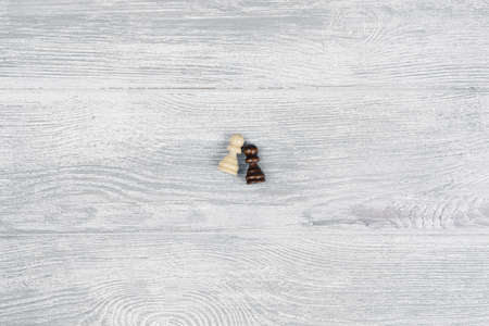 Black and white pawns on a wooden table. No to racism conceptの写真素材