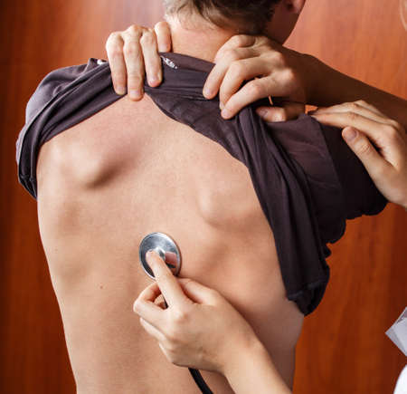 doctor listening to the patient's breathing through the stethoscope, the nurse listens to the...