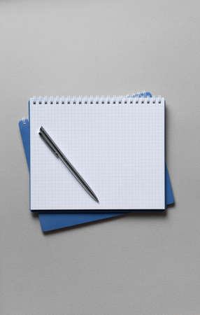 top view of a open blue notebook with pen on a gray background, school notebooks with a spiral...